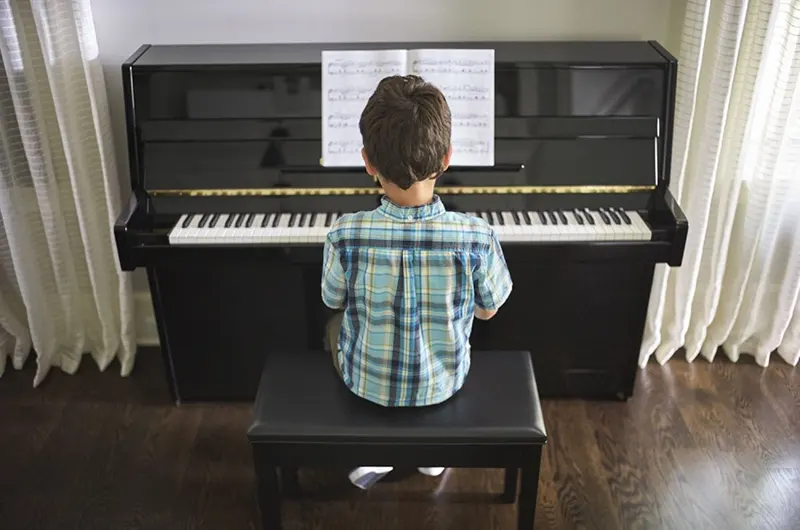 Niño tocando piano B1 Negro pulido de Yamaha