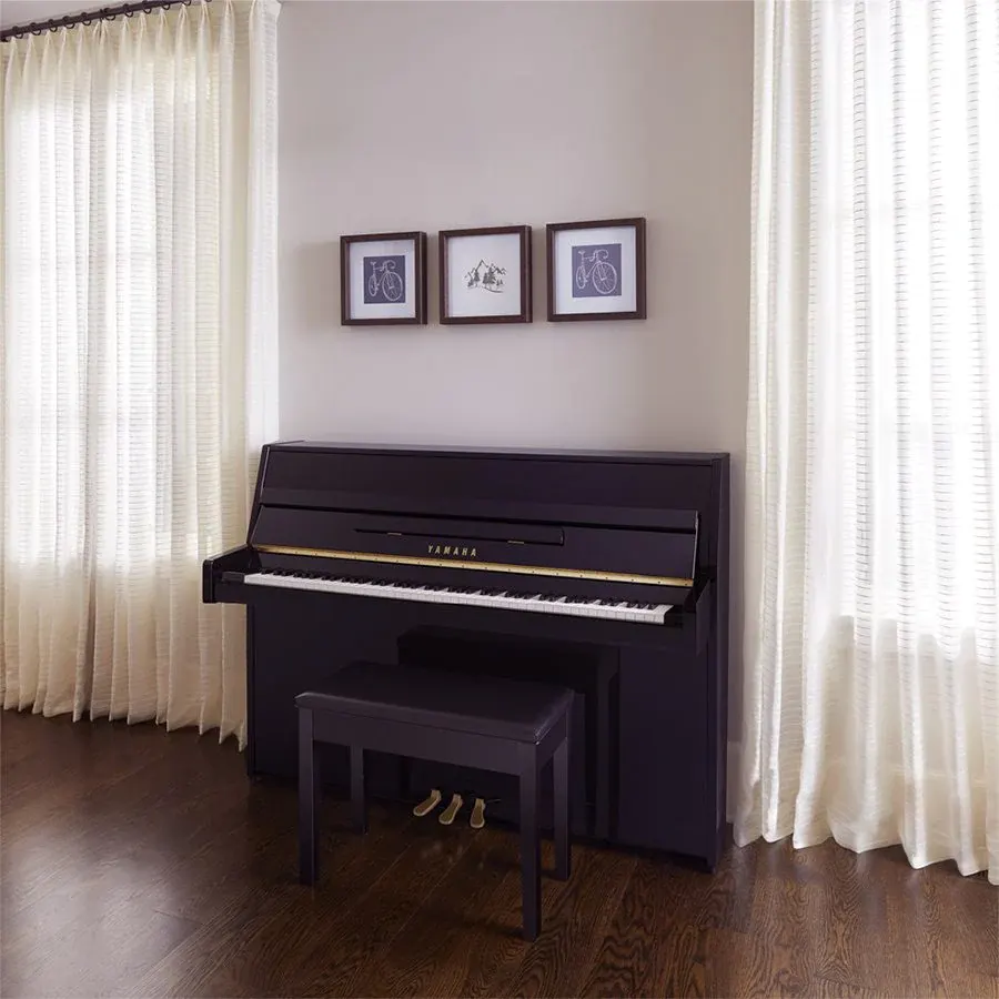 Piano compacto vertical B1 negro pulido en habitación de casa.