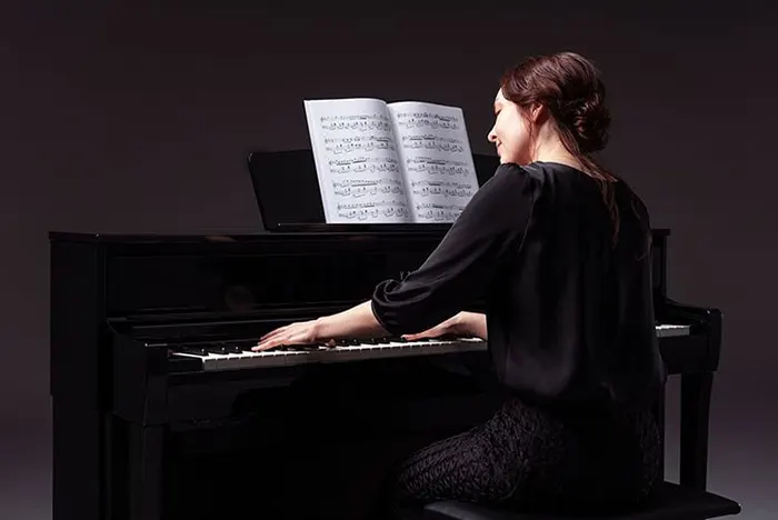 Mujer joven tocando piano CLP
