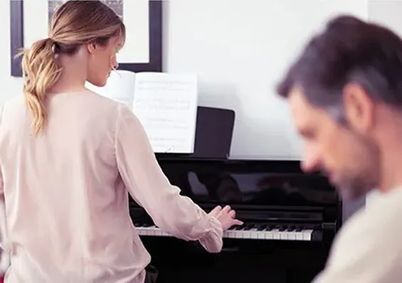 Mujer tocando el piano en presencia de su pareja