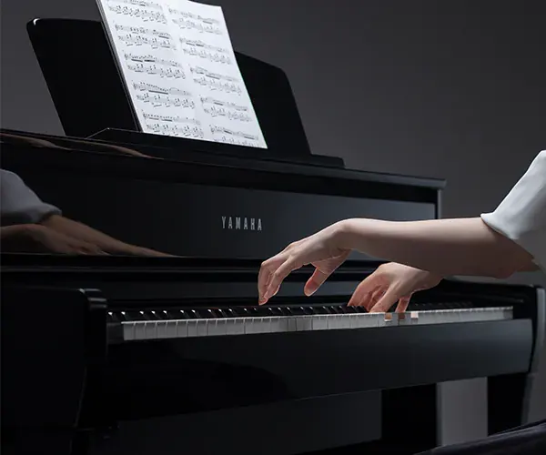 Manos de mujer tocando piano de cola CLP 765-GP Negro pulido