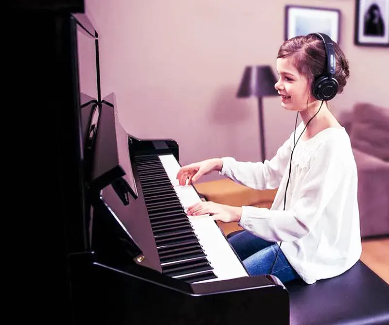 Niña tocando piano B3 Silent con auriculares