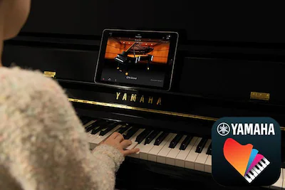 Mujer tocandopiano acústico con app Smart Pianist